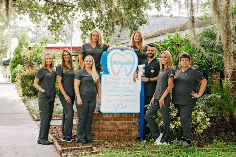 ESI Dentistry - Esthetic Smiles & Implants team standing outside of office holding a giant toothbrush